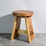Wooden stool on a gray floor with a plain background