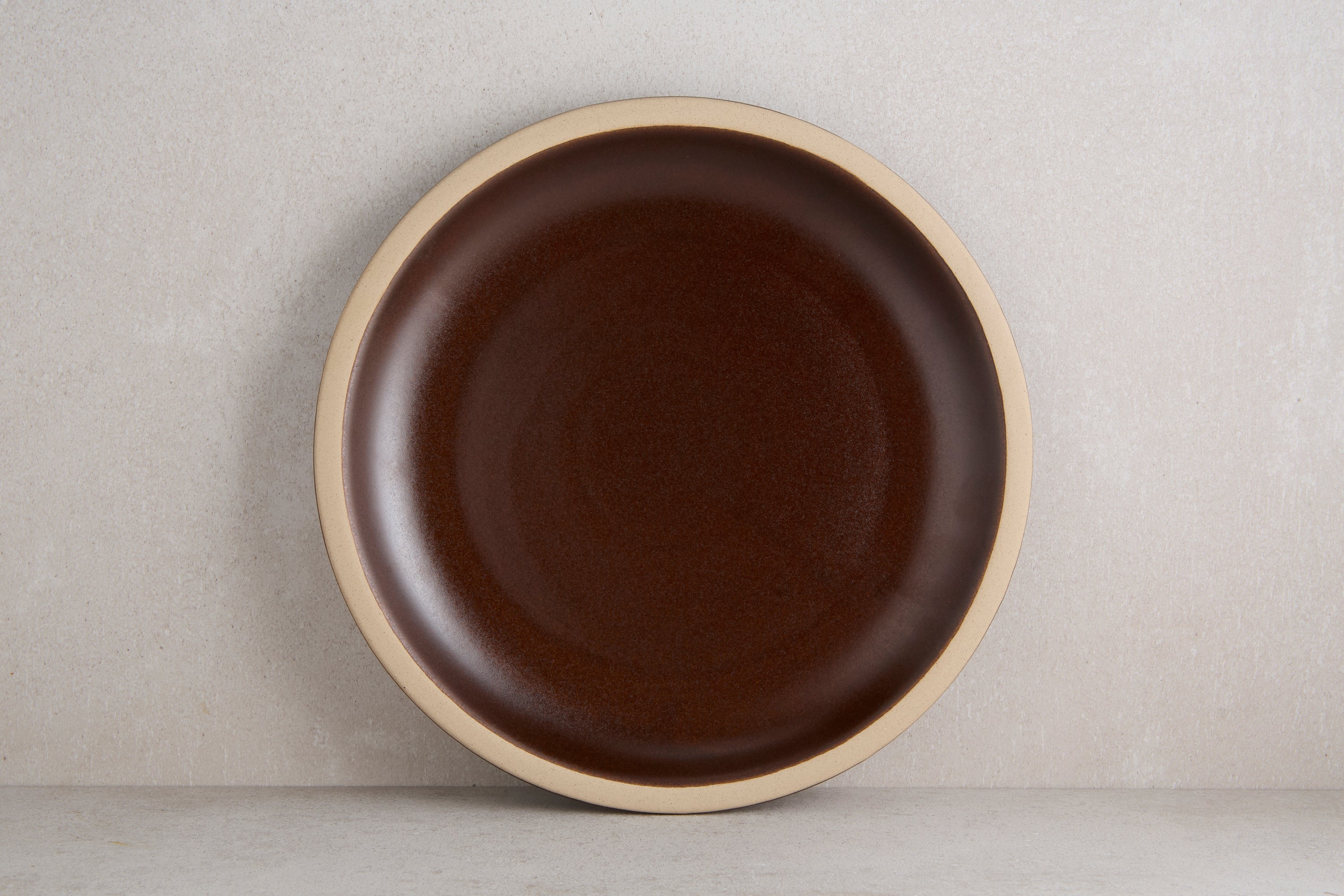Brown ceramic plate on a beige background