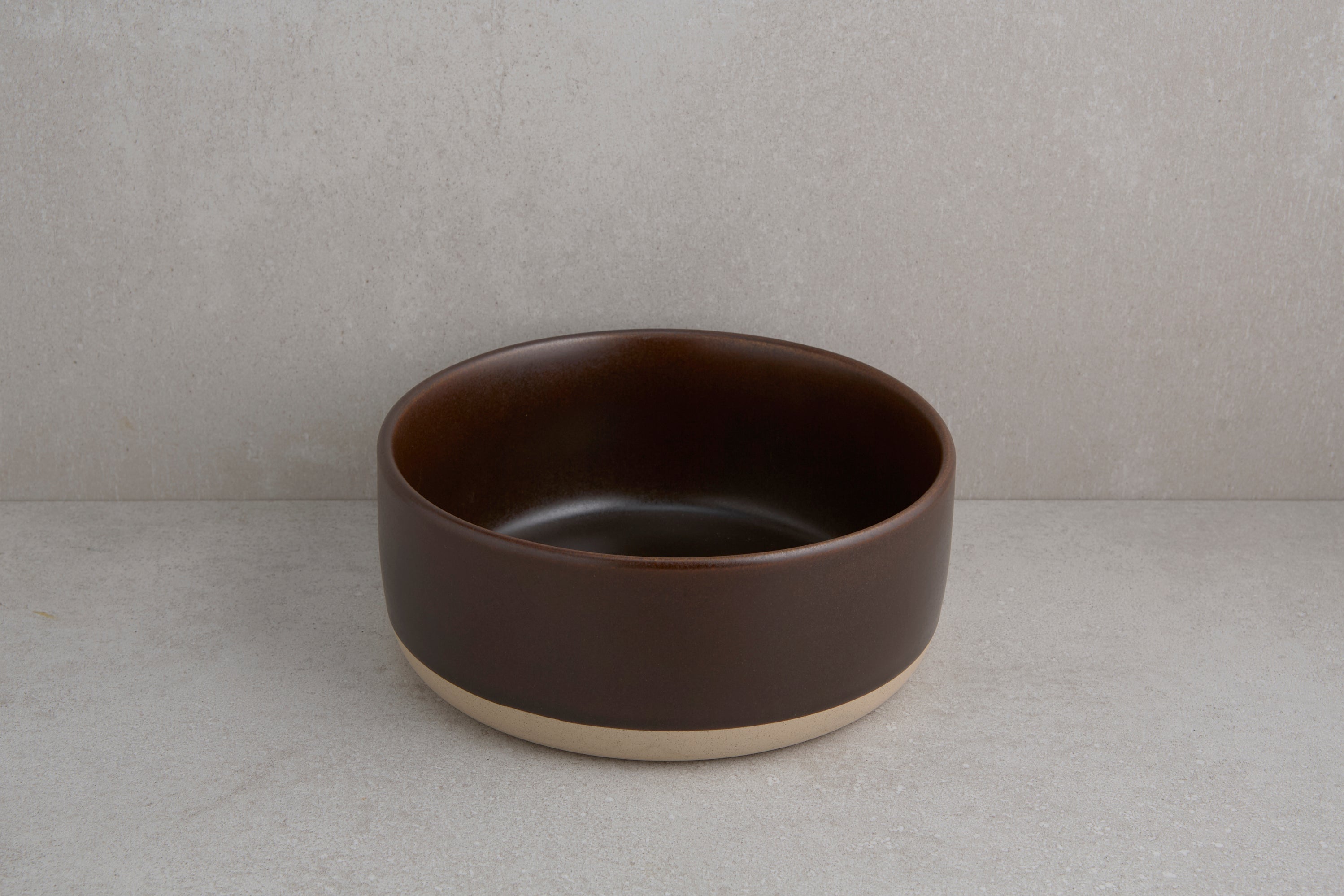 Brown ceramic bowl on a gray background
