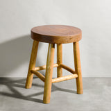 Wooden stool against a plain wall