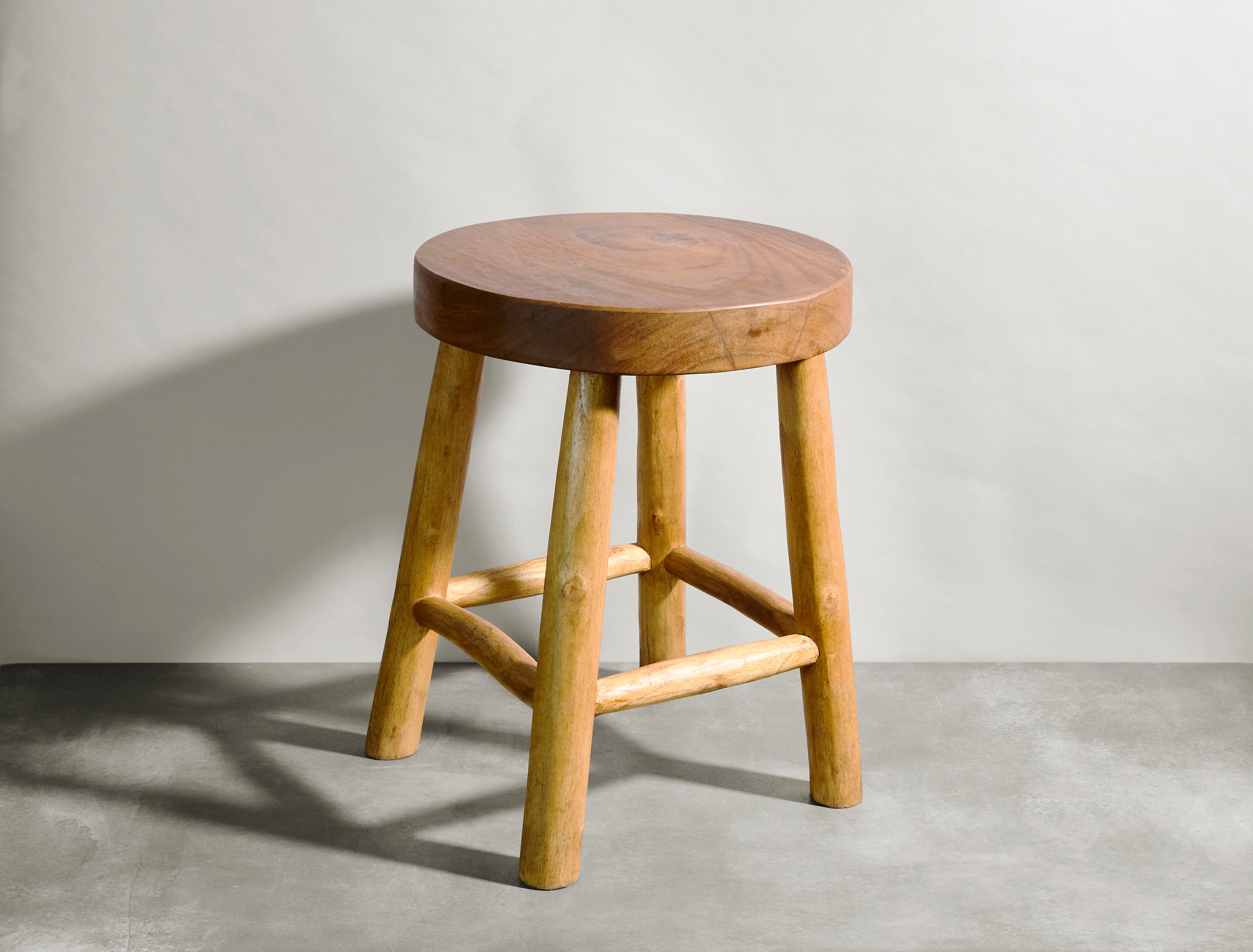 Wooden stool against a plain wall