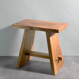 Wooden stool with a natural finish on a gray background
