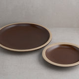 Two brown ceramic plates on a gray surface