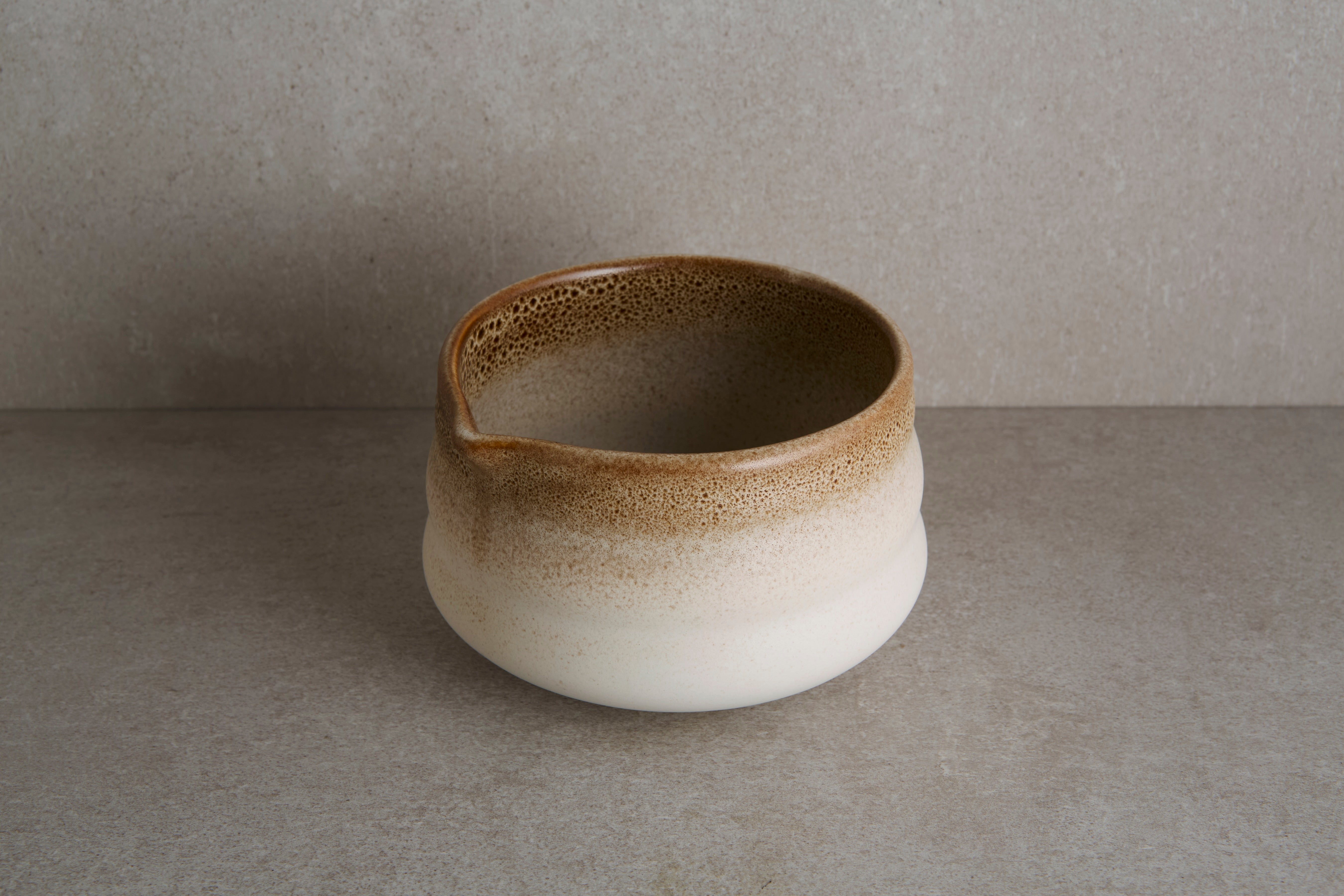 Ceramic bowl with brown and white gradient on a gray background. 
