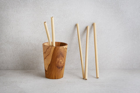 a wooden cup with straws in it